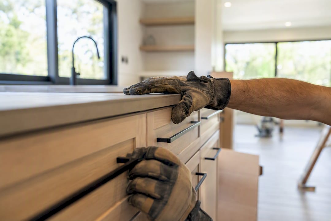 Hands inspecting cabinetry for punch list