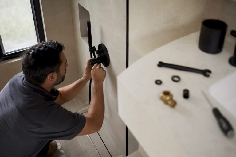 Hands installing modern bathroom faucet