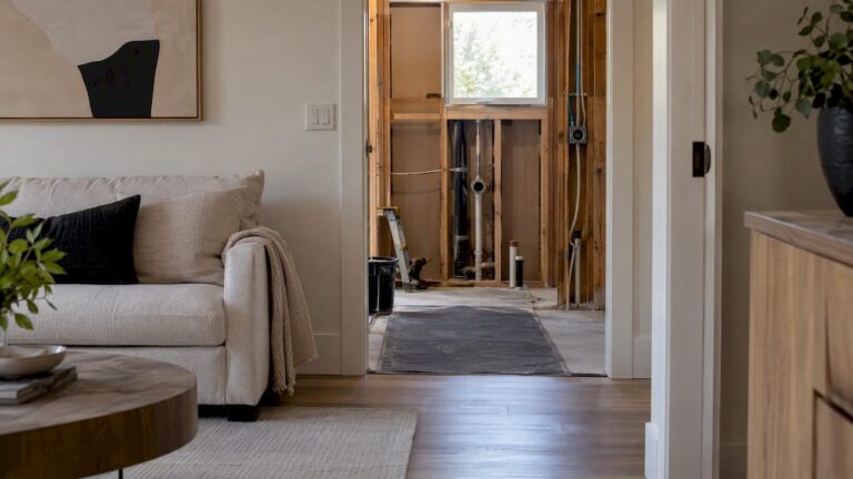 Finished living room beside an active bathroom remodel